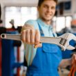 Plumber shows pipe wrenches at the showcase in plumbering store. Man buying sanitary engineering tools and equipment in shop